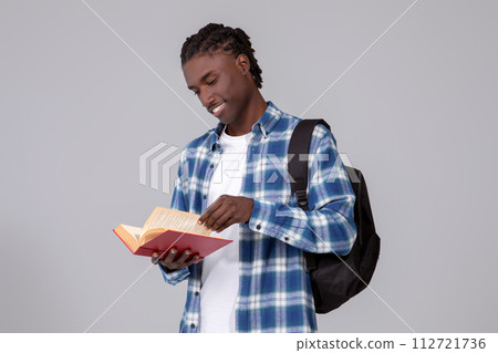 Study Concept. Smiling Young Black Student Guy With Book And Backpack Study Concept. Smiling Young Black Student Guy With Book And Backpack 112721736
