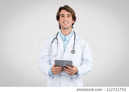 Smiling man doctor with tablet, symbolizing e-health services 112721758
