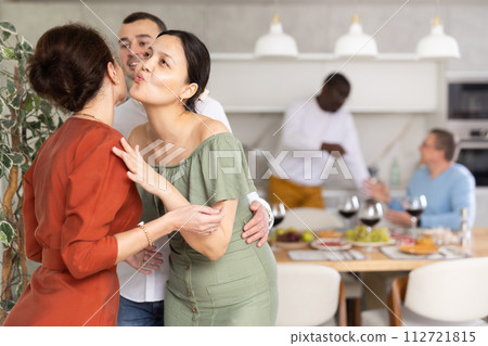 Happy middle-aged pair welcoming a woman at home Happy middle-aged pair welcoming a woman at home 112721815