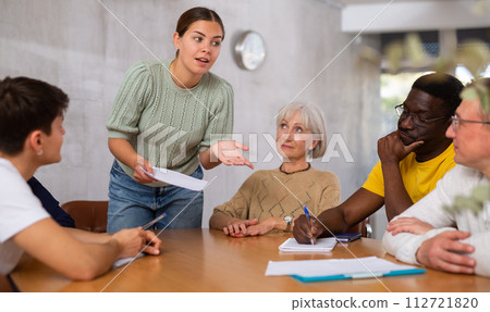 Young female manager holds table meetings for employees of different nationalities 112721820