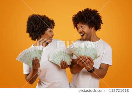 Emotional happy african american spouses showing money 112721918