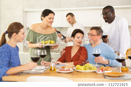 Multiethnic women and men friends chatting and drinking Multiethnic women and men friends chatting and drinking 112721925