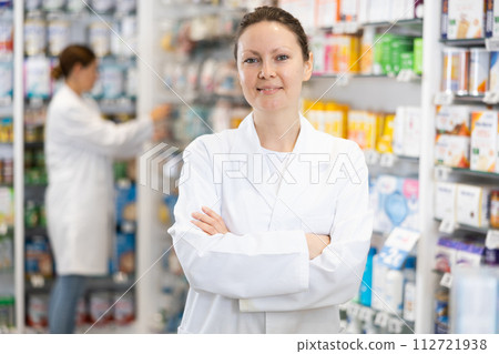 At pharmacy, apothecary waiting for customers and invites with gesture go to department of cosmetics At pharmacy, apothecary waiting for customers and invites with gesture go to department of cosmetics 112721938