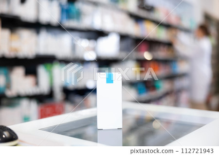 Box with cosmetics or healing cream on cash desk, against background of showcase with products in pharmacy Box with cosmetics or healing cream on cash desk, against background of showcase with products in pharmacy 112721943