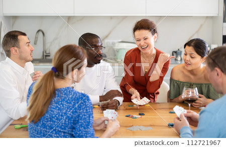Multiethnic women and men friends playing poker 112721967