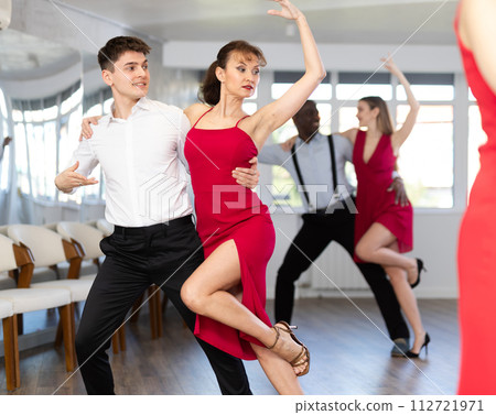 Young man and woman dancing tango in couple during lesson at studio 112721971