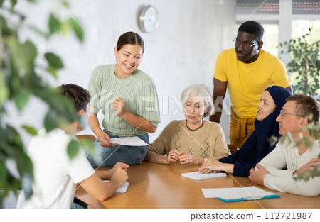 Group of multinational people discussing documents at table 112721987