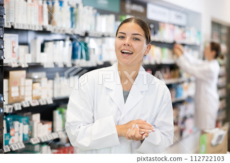 At pharmacy, apothecary waiting for customers and invites with gesture go to department of cosmetics 112722103