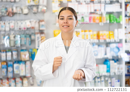 At pharmacy, apothecary waiting for customers and invites with gesture go to department of cosmetics 112722131