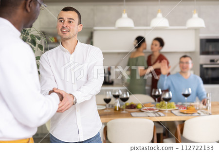 Happy middle-aged man welcoming his guest at home 112722133