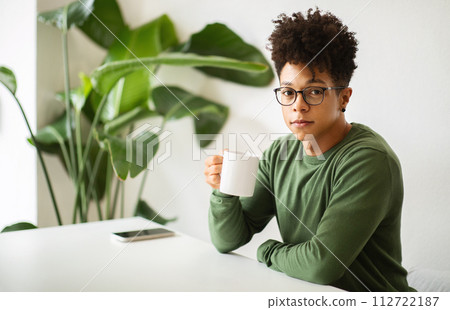 Millennial african american guy waiting for his friends at cafe Millennial african american guy waiting for his friends at cafe 112722187