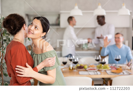 Happy middle-aged woman welcoming her guest at home 112722203
