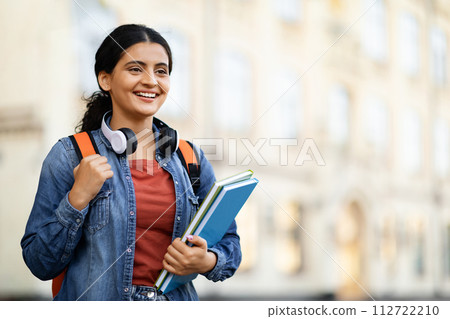 Positive young eastern lady student posing at university campus Positive young eastern lady student posing at university campus 112722210