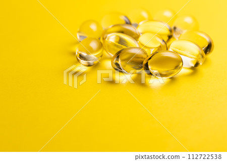 Yellow pill medicine supplement yellow background 112722538