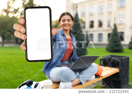 Positive eastern lady showing phone with blank screen, studying online 112722541