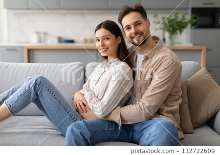 Happy couple relaxing together on cozy sofa at home 112722609