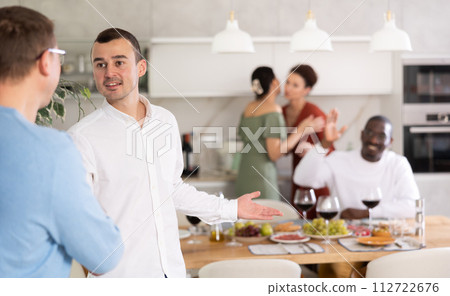 Happy middle-aged man welcoming his guest at home Happy middle-aged man welcoming his guest at home 112722676
