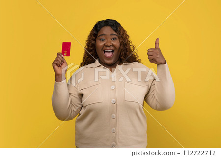 Happy chubby african american woman showing credit card Happy chubby african american woman showing credit card 112722712