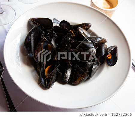 Delicious grilled mussels on plate, served with ali-oli sauce Delicious grilled mussels on plate, served with ali-oli sauce 112722866