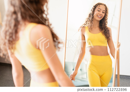 adolescent girl in sportswear in front of mirror at home adolescent girl in sportswear in front of mirror at home 112722896