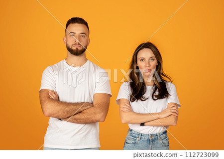 Serious and confident young man and woman in white t-shirts with arms crossed Serious and confident young man and woman in white t-shirts with arms crossed 112723099