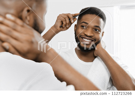 Combing man in bathroom 112723266