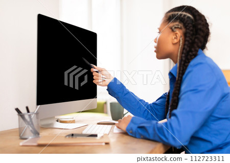 Focused female student using pen tablet with blank monitor 112723311