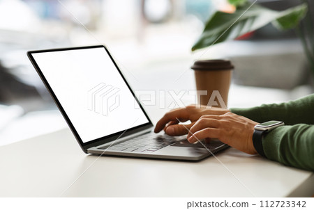 Cropped of african american guy typing on laptop, cafe interior Cropped of african american guy typing on laptop, cafe interior 112723342