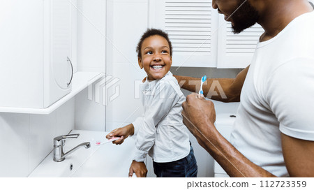 African-american girl brushing teeth with dad together 112723359