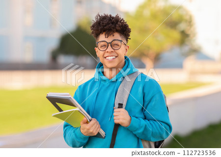 Portrait of smiling student guy posing with backpack and workbooks Portrait of smiling student guy posing with backpack and workbooks 112723536