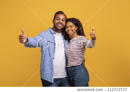 Happy Young African American Couple Showing Thumbs Up At Camera Happy Young African American Couple Showing Thumbs Up At Camera 112723537
