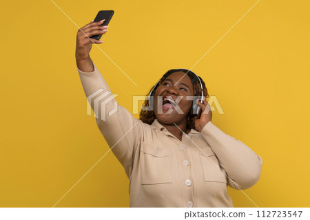 Funny chubby black lady taking selfie on smartphone 112723547