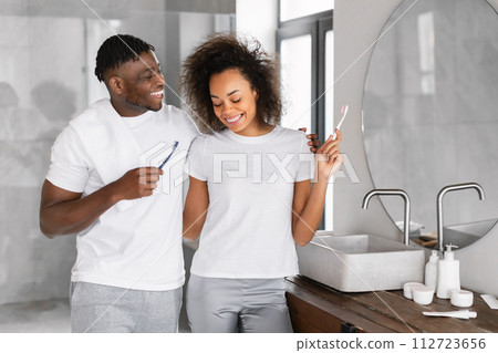 black couple brushing teeth in morning in modern bathroom indoors 112723656
