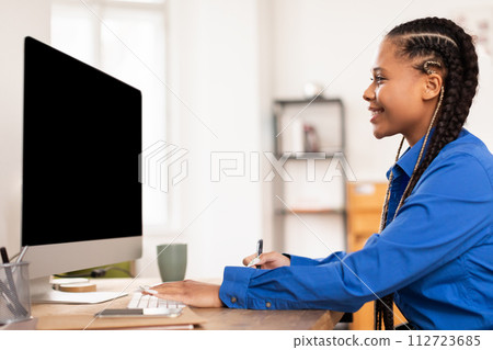 Focused female student engaged in online learning with computer at home Focused female student engaged in online learning with computer at home 112723685