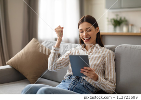 Happy young woman celebrating success with tablet 112723699