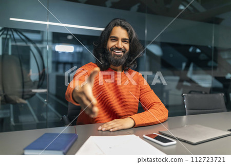 Smiling friendly indian man manager outstretching hand at camera Smiling friendly indian man manager outstretching hand at camera 112723721
