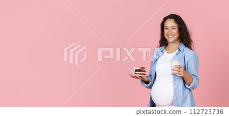 Positive young pregnant woman with cake and glass of milk 112723736