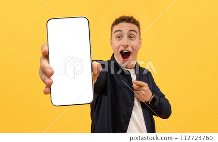 Shocked young guy showing smartphone with blank screen Shocked young guy showing smartphone with blank screen 112723760