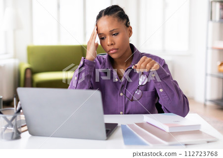 Stressed lady student with laptop and glasses feeling overwhelmed Stressed lady student with laptop and glasses feeling overwhelmed 112723768