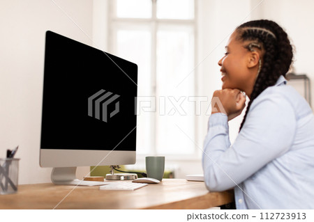 Happy lady student looking at computer, lost in concentration or e-learning content 112723913