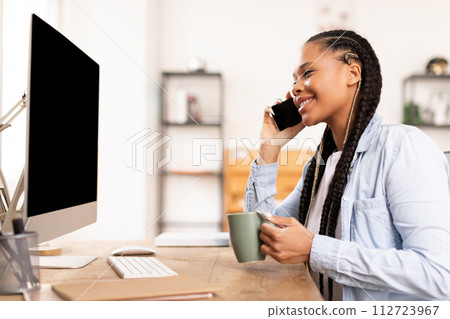 Smiling african american lady student with coffee mug on phone call 112723967