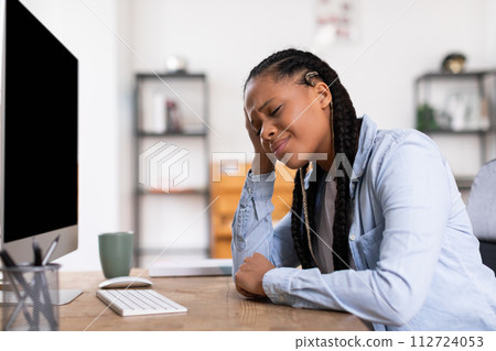 Tired lady student feeling overwhelmed with online studies Tired lady student feeling overwhelmed with online studies 112724053