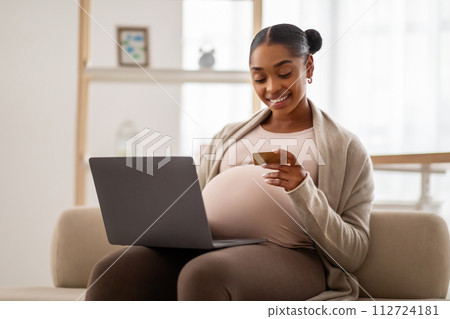 Cheerful black pregnant woman mother shopping online for her baby 112724181