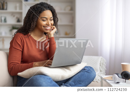 Black Female Surfing Internet On Laptop And Relaxing On Couch At Home Black Female Surfing Internet On Laptop And Relaxing On Couch At Home 112724230