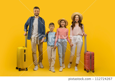 Happy Young Family Of Four Holding Hands And Walking With Suitcases 112724267