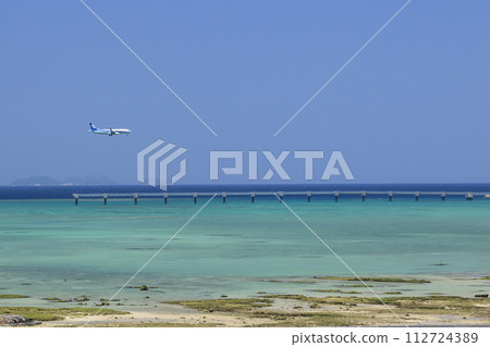 Aircraft landing at Naha Airport with the blue sea in the background 112724389