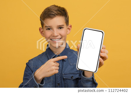 Smiling Handsome Teen Boy Pointing At Empty Smartphone Screen In His Hand 112724402