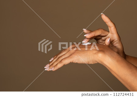 Female hands applying moisturizing cream 112724431
