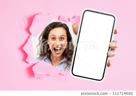 Cheerful shocked excited young european woman with open mouth showing smartphone with empty screen 112724680
