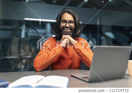 Upbeat professional indian guy working in office, using laptop 112724772